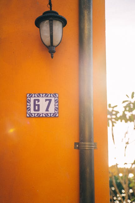 House number 67 on vibrant orange wall